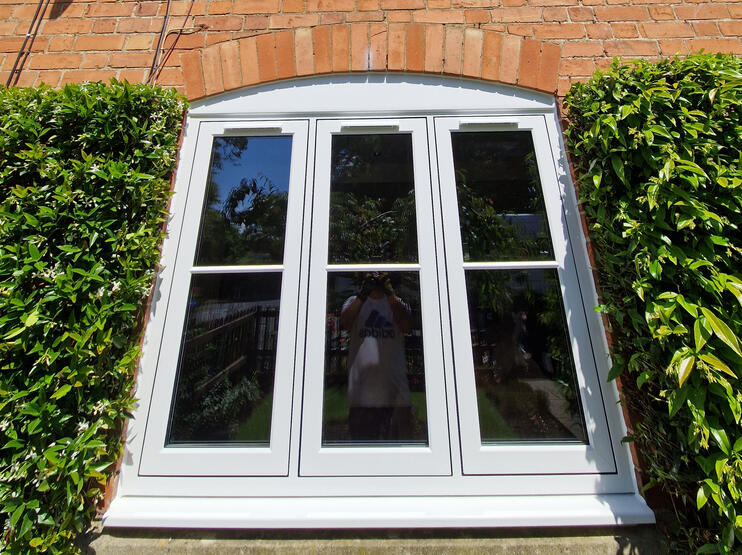 White triple-pane window in brick wall