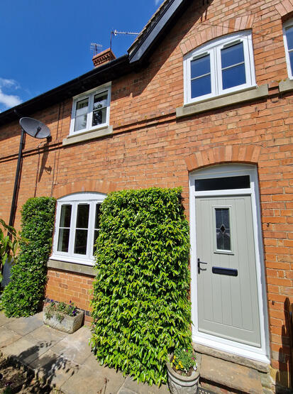 Brick cottage with white windows and ivy